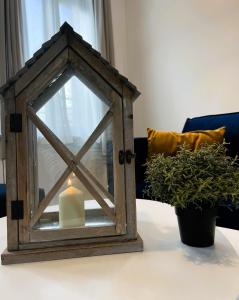 een kaars in een houten frame op een tafel met twee planten bij Villa Saint Jacques , Duplex Les Galets in Le Tréport