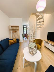 een woonkamer met een blauwe bank en een tafel bij Villa Saint Jacques , Duplex Les Galets in Le Tréport