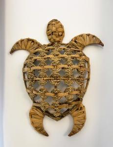 een houten schildpad met kettingen aan een witte muur bij Villa Saint Jacques , Duplex Les Galets in Le Tréport