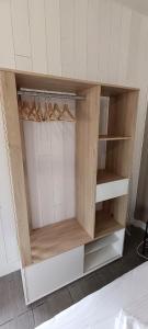 a cupboard with wooden shelves and hangers in a room at Sirius - SILS in Caen