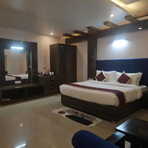 een slaapkamer met een groot bed en een grote spiegel bij Aarunya Hotel And Resort in Rajgir