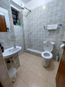 a bathroom with a toilet and a sink at Polea Hapa in Ngong