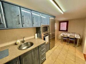 a kitchen with a sink and a kitchen with a table at Andra Mari Etxea - Apartamento en parte antigua in Bermeo