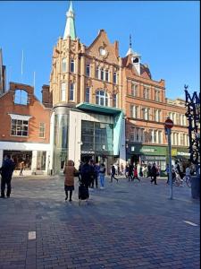 un grupo de personas caminando delante de un edificio en City Center Leicester en Leicester