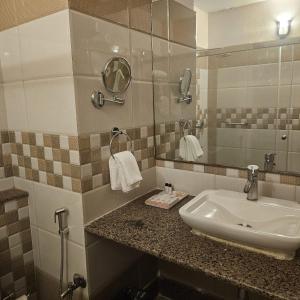 y baño con lavabo y espejo. en Aarunya Hotel And Resort, en Rajgir