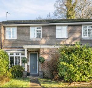 a brick house with a blue door at Weybridge Home in Weybridge