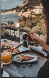 eine Person, die an einem Tisch mit einem Teller Essen sitzt in der Unterkunft Tango Studios in Paleokastritsa