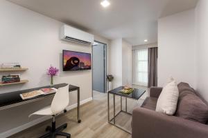 a living room with a couch and a desk at Citadines Sukhumvit 16 Bangkok in Bangkok