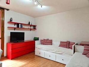 a living room with a white couch and a red cabinet at Hostdomus - La Via Lattea e Le Pleiadi in Cesana Torinese