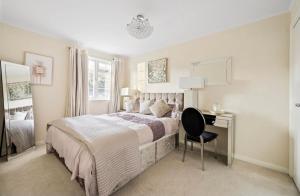 a bedroom with a bed and a desk with a chair at Weybridge Home in Weybridge