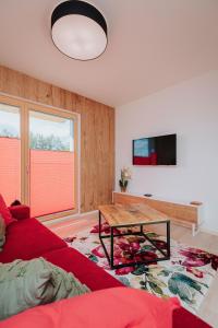 a living room with a red couch and a table at Apartmán Collin X41 in Dolný Kubín