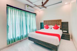 una camera da letto con un grande letto con cuscini rossi di Hotel Golden Palace Lodging and Boarding a Thane