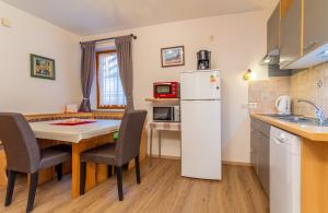 uma pequena cozinha com uma mesa e um frigorífico em Landhaus Toni em Neustift im Stubaital