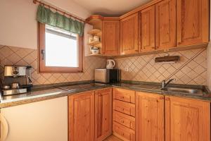 uma cozinha com armários de madeira, um lavatório e uma janela em Vineyard Chalet Hansel and Gretel - Happy Rentals em Otočec