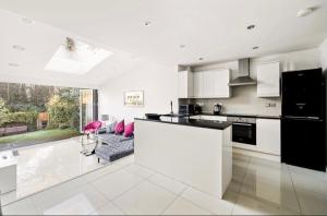 a kitchen with a counter top and a living room at Weybridge Home in Weybridge