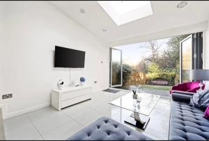 a living room with a couch and a tv at Weybridge Home in Weybridge