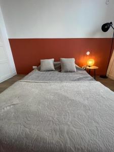 uma cama grande num quarto com uma parede vermelha em Chambre Lumineuse en plein centre-ville de Gaillac em Gaillac