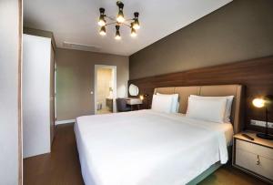 a bedroom with a large white bed and a chandelier at Radisson Residences Vadistanbul in Istanbul