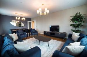 a living room with a blue couch and a television at Radisson Residences Vadistanbul in Istanbul