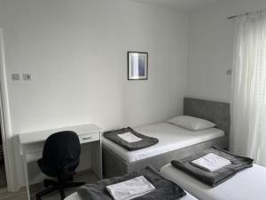 a room with two beds and a desk and a chair at Apartments Gaspar in Podaca