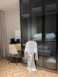 a room with a glass cabinet with a white robe at Square INN Garden Aparthotel in Tirana +277 photos
