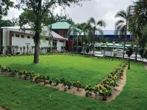 un parque con flores frente a un edificio en Aarunya Hotel And Resort, en Rajgir