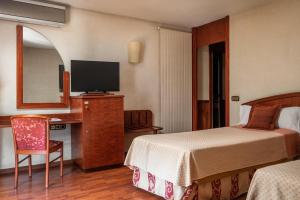 a hotel room with a bed and a desk with a television at ALEGRIA President in Andorra la Vella