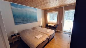 a bedroom with a bed and a large painting on the wall at Telemark Motel and Apartment in Hauggrend