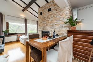 a living room with a wooden table and a brick wall at B&B Villa Sumrak Plitvica in Plitvica Selo