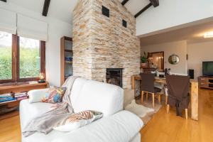 uma sala de estar com um sofá branco e uma lareira de pedra em B&B Villa Sumrak Plitvica em Plitvica selo