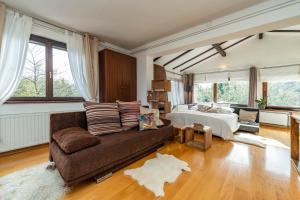 uma sala de estar com um sofá e uma cama em B&B Villa Sumrak Plitvica em Plitvica selo