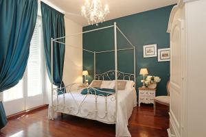 ローマにあるAvignonesi Suitesの青い壁のベッドルーム1室(天蓋付きベッド1台付)