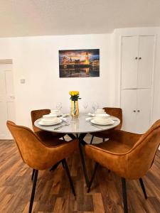 a dining room table with chairs and a vase of flowers at Luxury London apartment in prime location in London