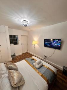 a bedroom with a large bed with a tv on the wall at Luxury London apartment in prime location in London