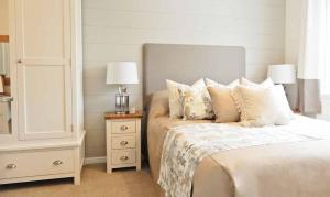 una camera da letto con letto con cuscini e comodino di Newperran Holiday Park a Newquay