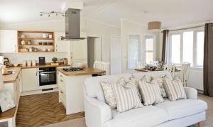un soggiorno con divano bianco e una cucina di Newperran Holiday Park a Newquay