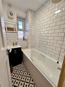 a white bathroom with a tub and a sink at Luxury London apartment in prime location in London