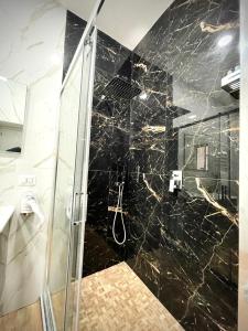 a bathroom with a shower with black marble at Il Paradiso di Dante in Naples