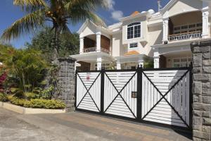 a house with a black and white gate at Apartment Hibiscus in Grand-Baie