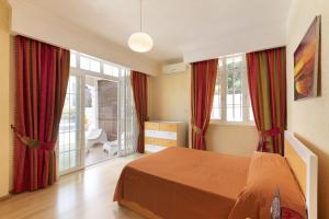 a bedroom with red curtains and a bed in a room at Apartment Orchid in Mont Choisy +21 photos