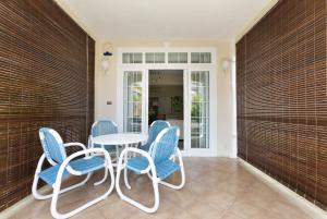 a patio with blue chairs and a table at Apartment Orchid in Mont Choisy