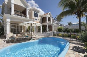a house with a swimming pool in front of a house at Apartment Orchid in Mont Choisy