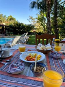 un tavolo da picnic con cibo, succo d'arancia e bevande di Moana Ilhabela a Ilhabela