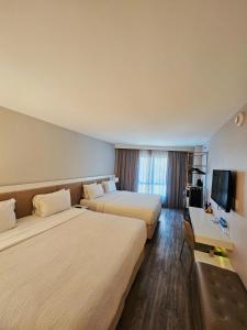 a hotel room with two beds and a television at Radisson Rio de Janeiro Barra in Rio de Janeiro