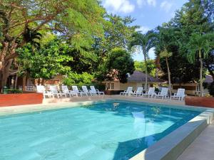 a swimming pool with white chairs and trees at Malibu Samed Resort in Ko Samed