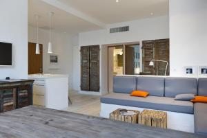 a living room with a blue couch and a kitchen at Les Barques, Vue splendide sur le port de Cassis in Cassis