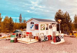 una pequeña casa de juegos con sillas rojas en una terraza en Offroadcamp, en Sörsjön