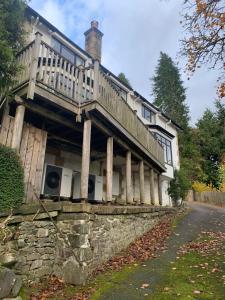 a house with a deck on top of a stone wall at The Sheiling in Saint Fillans