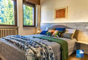 a bedroom with a bed in a room with two windows at [Asiago Centre] New Modern House in Asiago