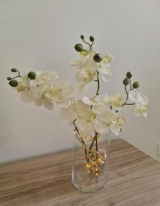 eine Vase voller weißer Blumen auf einem Tisch in der Unterkunft Studio Centre Douai - Wifi in Douai